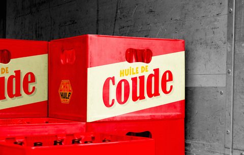 Caisse rouge marquée Huile de Coude.