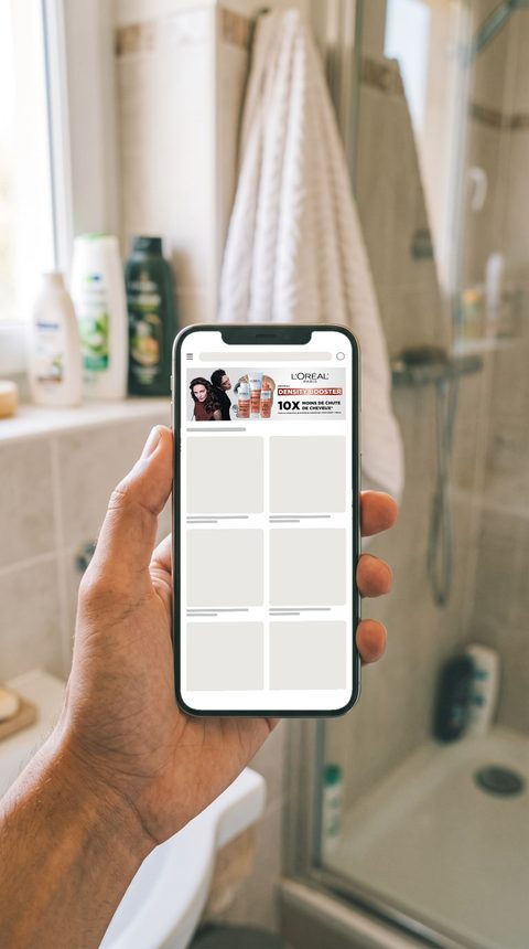 Mise en situation : bannière L’Oréal Paris Density Booster sur un téléphone, dans une salle de bain.