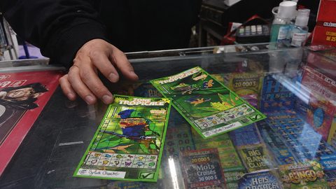 Les trois billets de la série Zone Tropicale posés sur un comptoir de dépanneur.