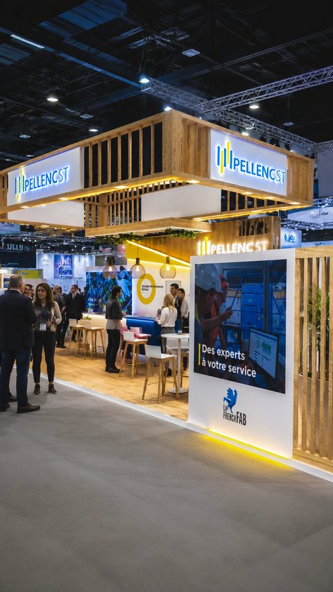 Stand Pellenc ST au salon Pollutec, avec structure en bois, logos lumineux et visiteurs.